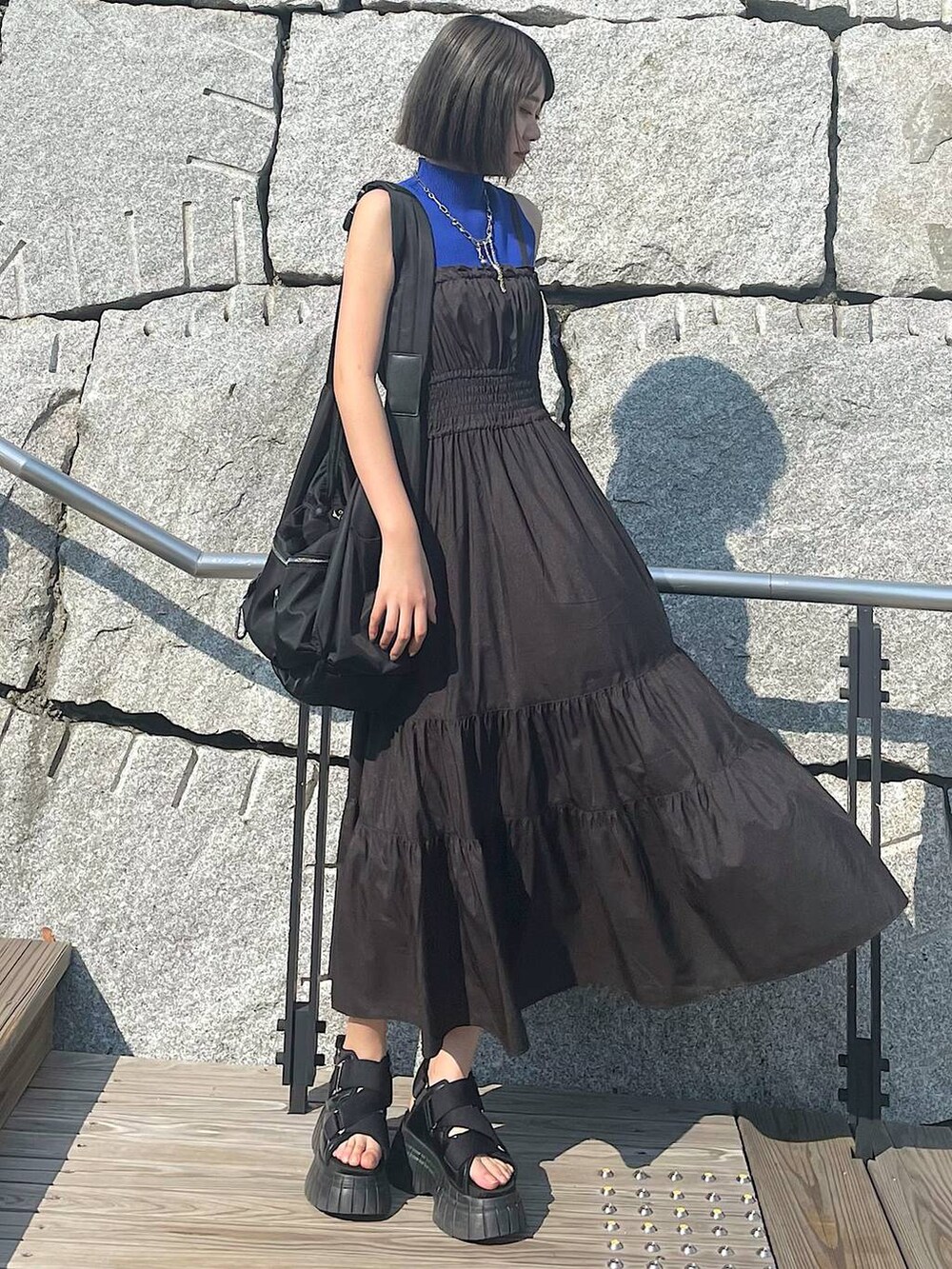 ブラック系のスニーカー、ブラック系のワンピース、シルバー系のネックレスを着用したレディースの夏コーディネートの7枚目の写真