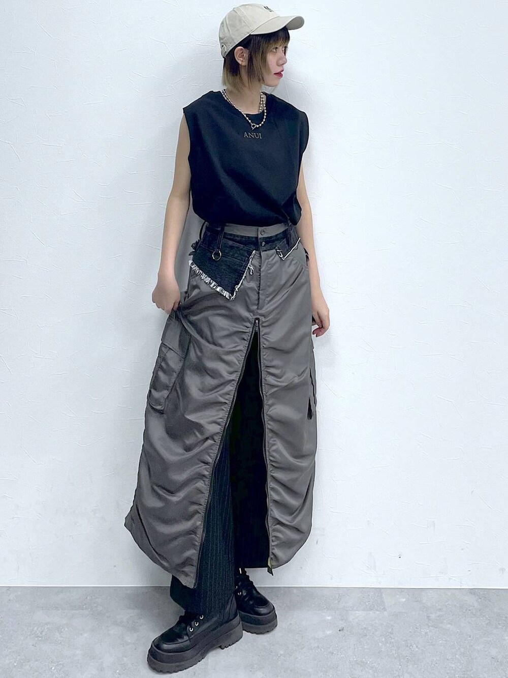 ブラック系のスラックス、ブラック系のTシャツ/カットソー、ブラック系のブーツを着用したレディースの春コーディネートの2枚目の写真