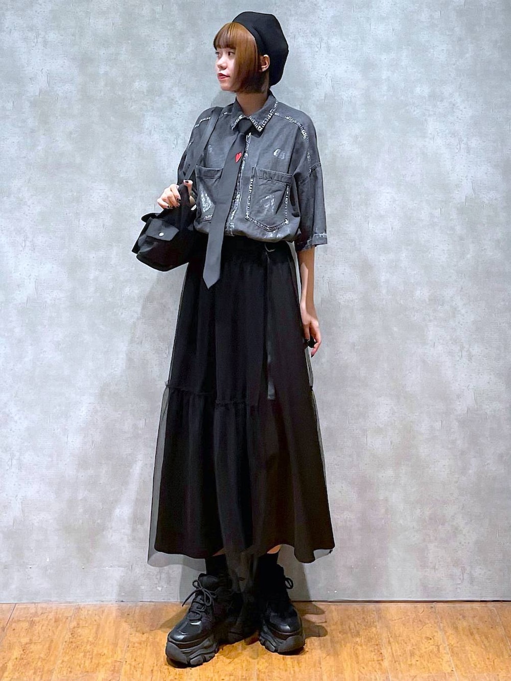 ブラック系のショルダーバッグ、ブラック系のスニーカー、ブラック系のシャツ/ブラウスを着用したレディースの夏コーディネートの2枚目の写真