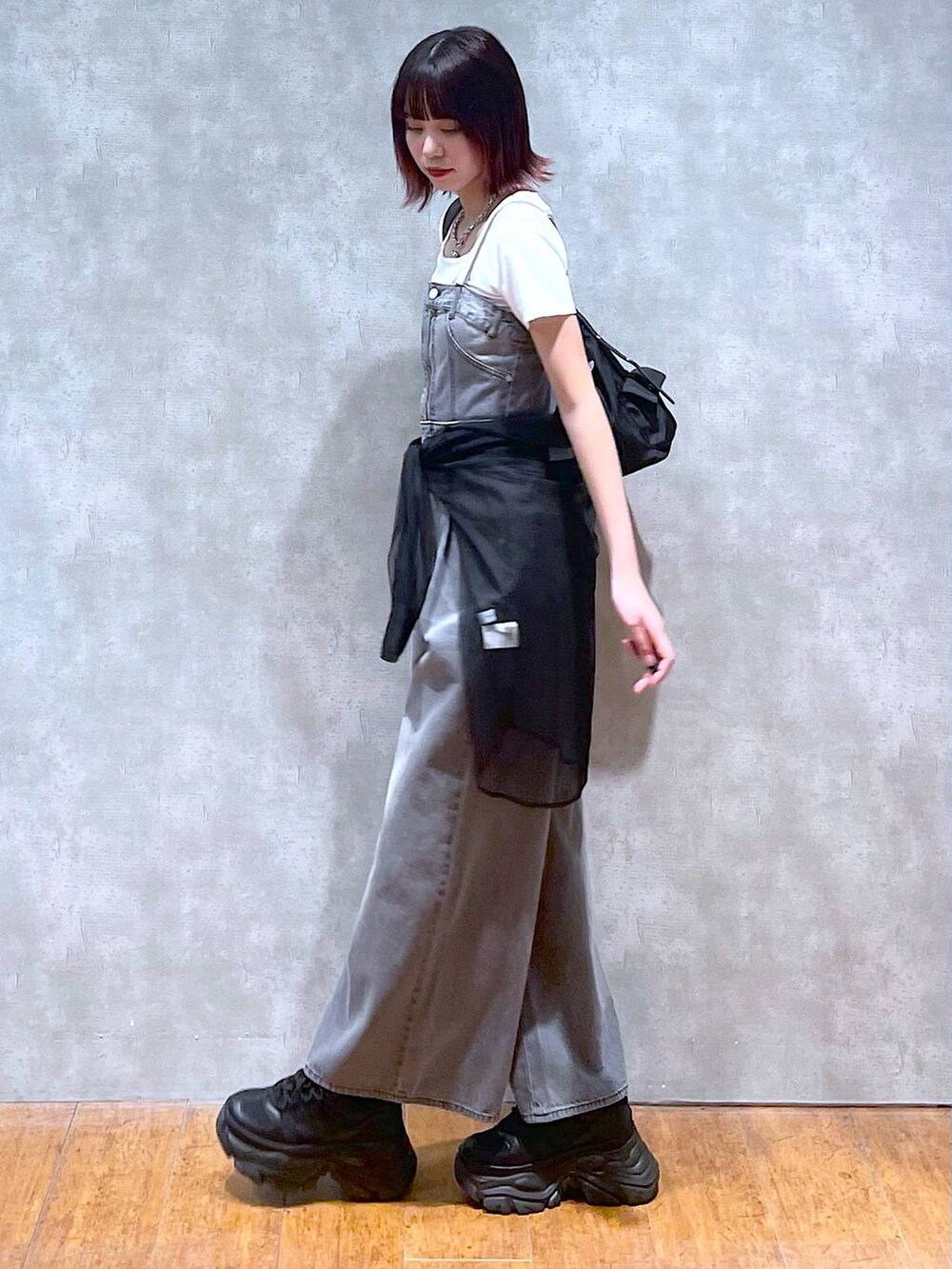 ブラック系のショルダーバッグ、ブラック系のサロペット/オーバーオール、ブラック系のスニーカーを着用したレディースの春コーディネートの7枚目の写真