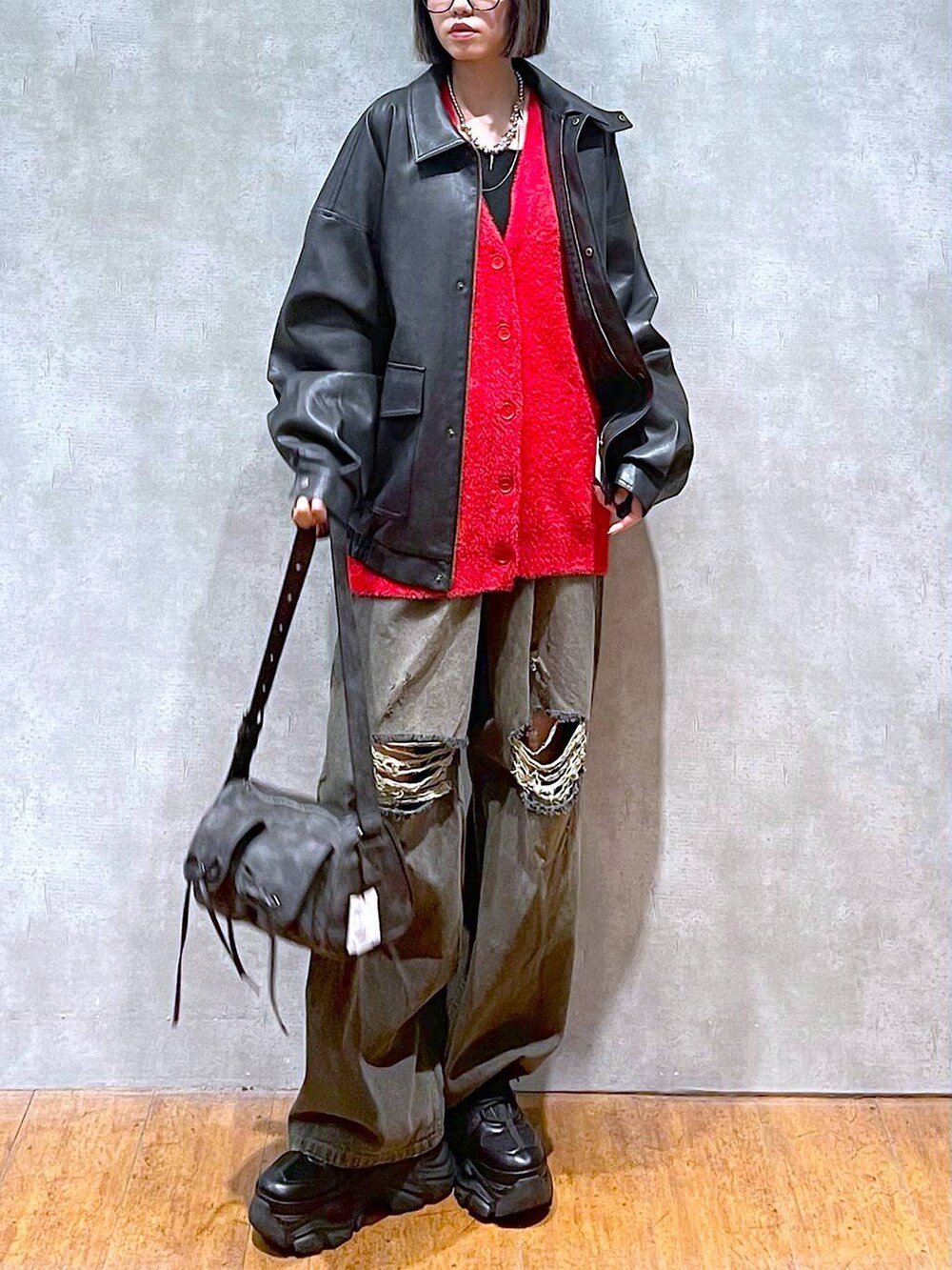 ブラック系のスニーカー、ブラック系のブルゾン、ブラック系のデニムパンツを着用したレディースの秋コーディネートの9枚目の写真