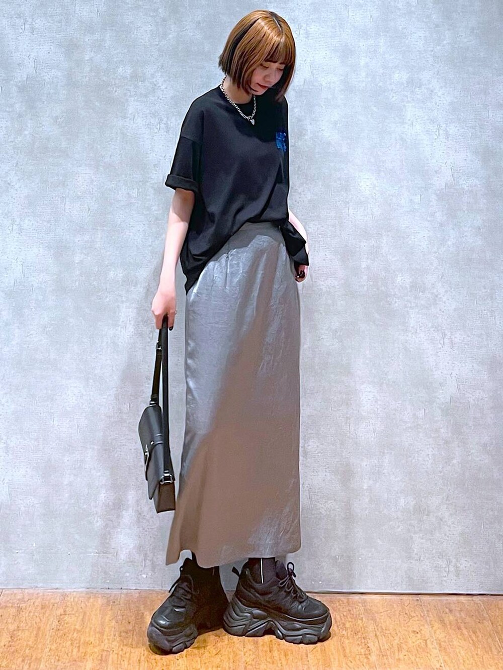 ブラック系のスニーカー、ブラック系のハンドバッグ、ブラック系のTシャツ/カットソーを着用したレディースの夏コーディネートの5枚目の写真