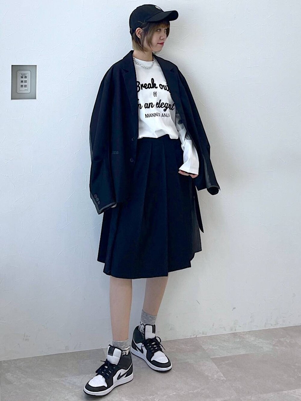 ブラック系のテーラードジャケット、ブラック系のスラックス、ブラック系のキャップを着用したレディースの冬コーディネートの2枚目の写真