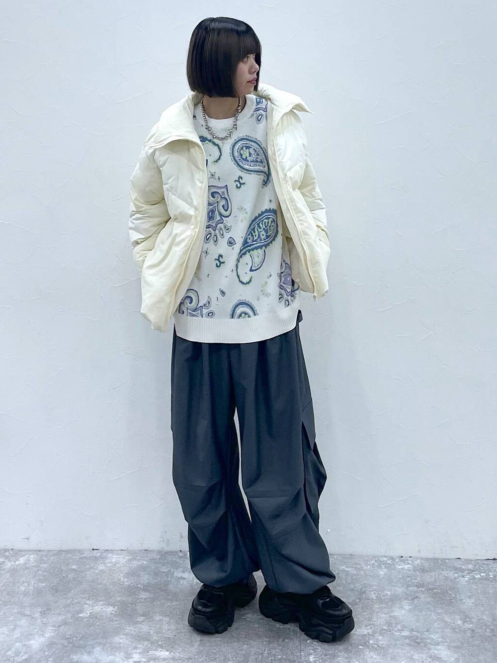 ブラック系のスニーカー、グレー系のカーゴパンツ、ホワイト系のブルゾンを着用したレディースの秋コーディネートの2枚目の写真