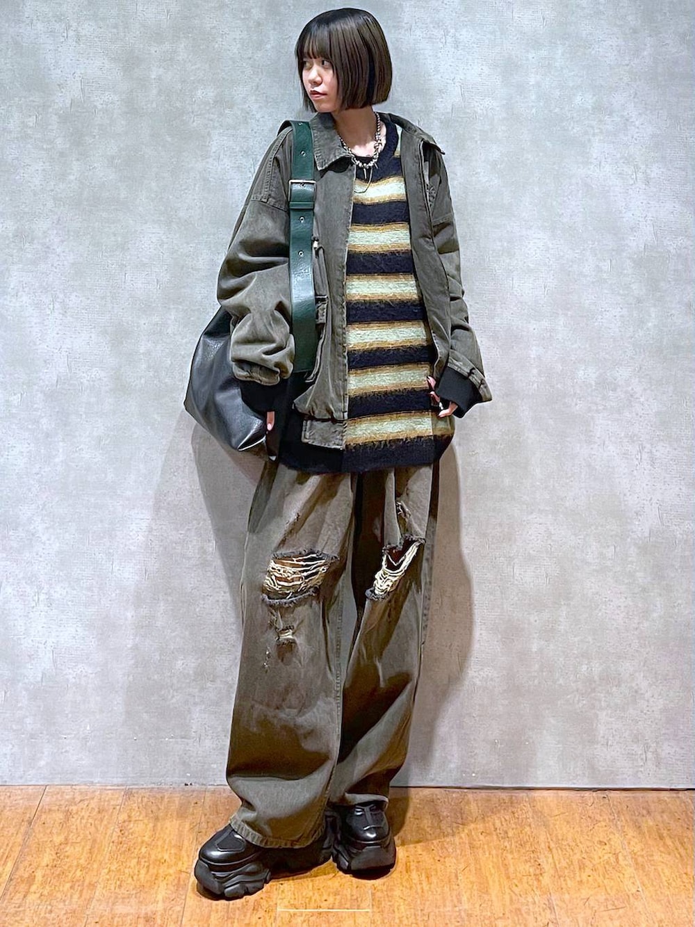 ブラック系のスニーカー、ブラック系のデニムパンツ、ブラック系のブルゾンを着用したレディースの秋コーディネートの9枚目の写真