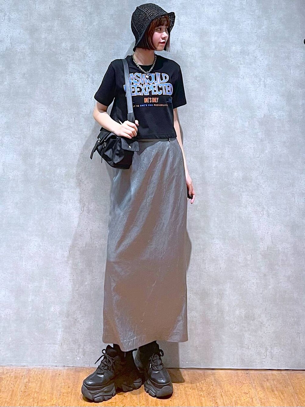 ブラック系のショルダーバッグ、ブラック系のスニーカー、ブルー系のスカートを着用したレディースの夏コーディネートの2枚目の写真