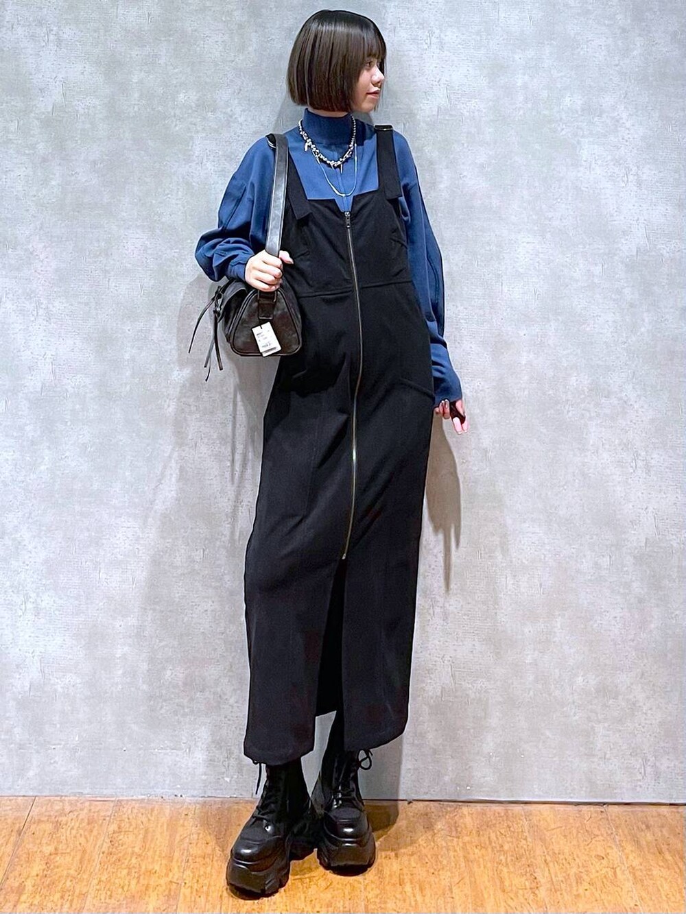 ブラック系のショルダーバッグ、ブラック系のブーツ、ブルー系のニット/セーターを着用したレディースの秋コーディネートの10枚目の写真