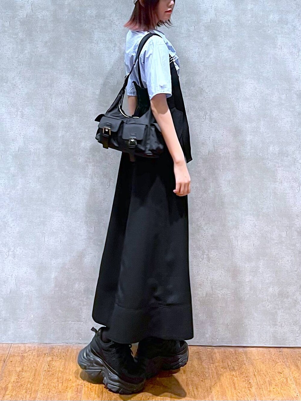 ブラック系のショルダーバッグ、ブラック系のスニーカー、ブラック系のスカートを着用したレディースの春コーディネートの4枚目の写真