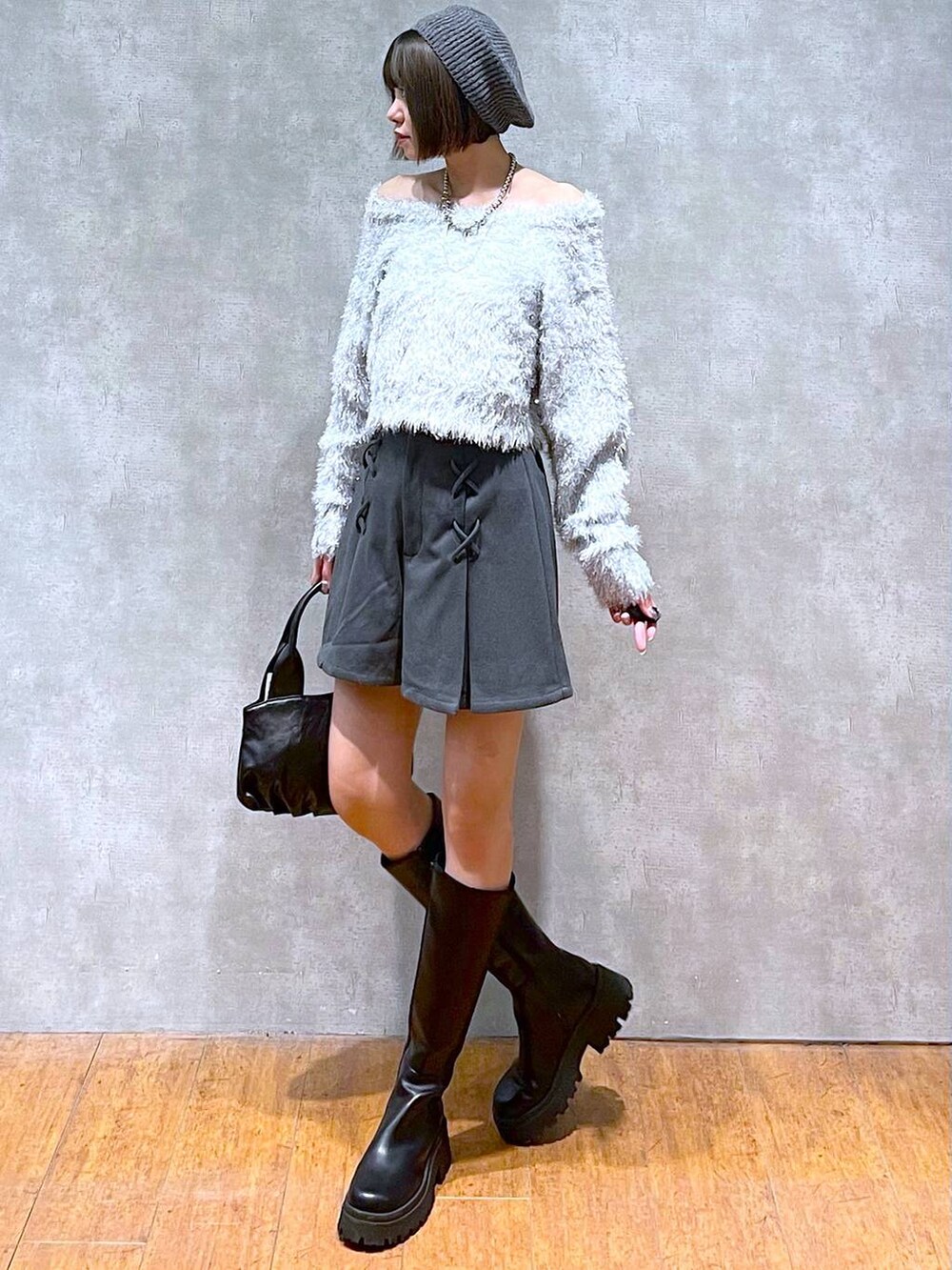 グレー系のその他パンツ、ブラック系のハンドバッグ、ブラック系のブーツを着用したレディースの秋コーディネートの5枚目の写真