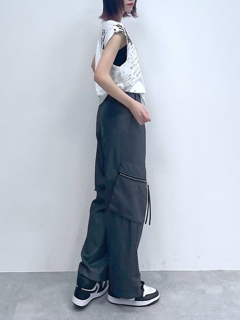 グレー系のスラックス、ホワイト系のTシャツ/カットソー、シルバー系のネックレスを着用したレディースの夏コーディネートの6枚目の写真