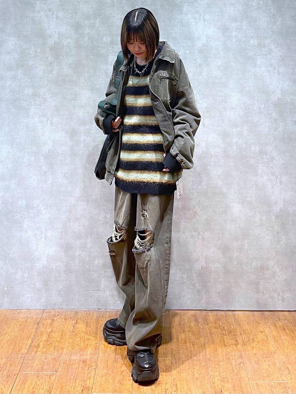 ブラック系のスニーカー、ブラック系のデニムパンツ、ブラック系のブルゾンを着用したレディースの秋コーディネートの5枚目の写真