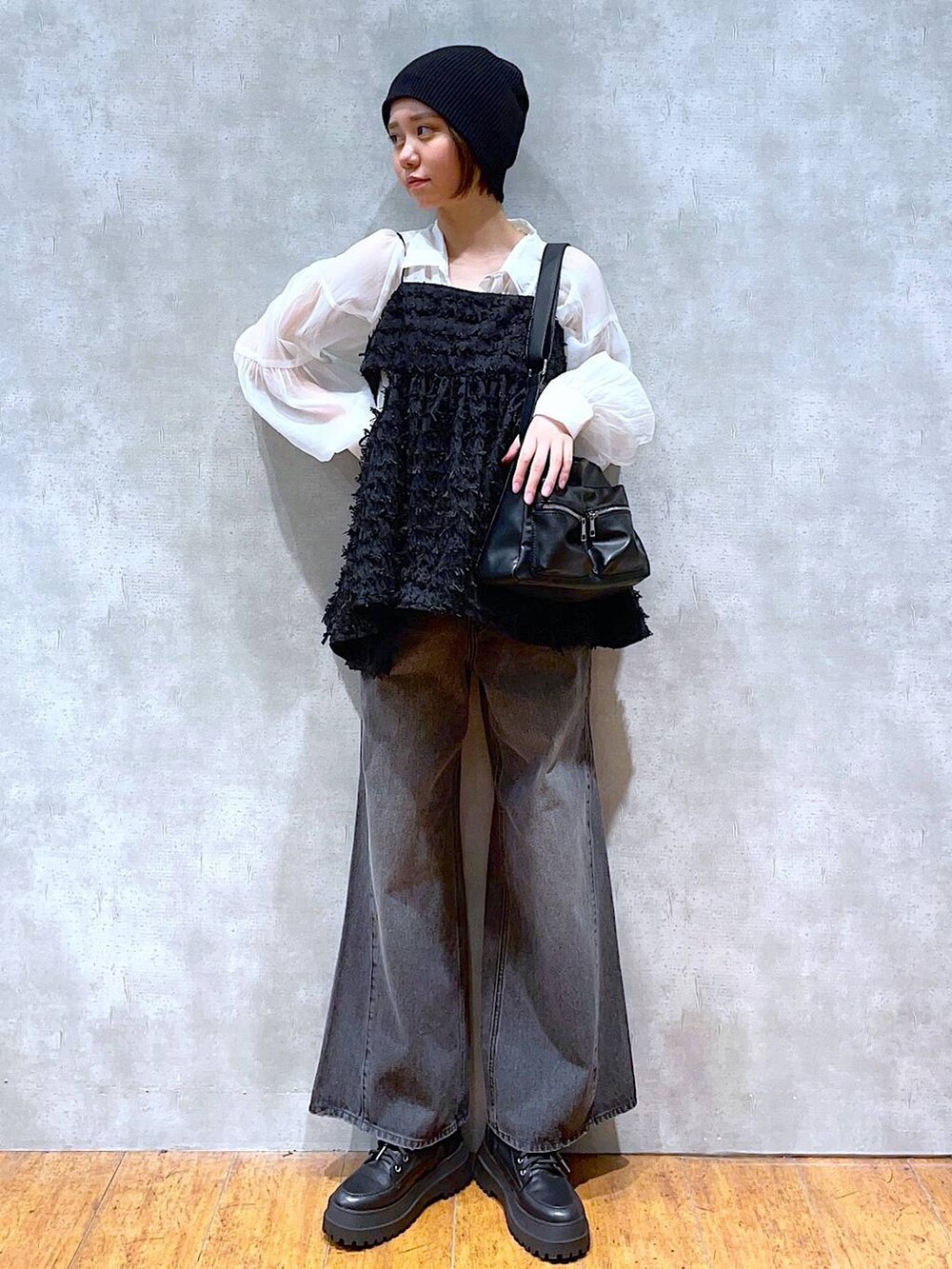 ブラック系のブーツ、ブラック系のデニムパンツ、ホワイト系のシャツ/ブラウスを着用したレディースの夏コーディネートの3枚目の写真