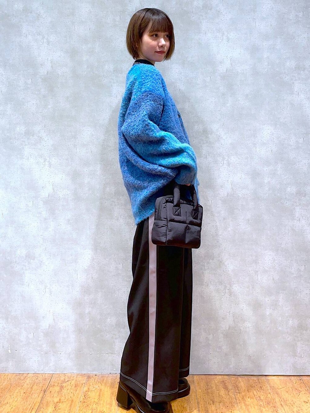 ブラック系のブーツ、ブラック系のその他パンツ、ブラック系のハンドバッグを着用したレディースの秋コーディネートの2枚目の写真