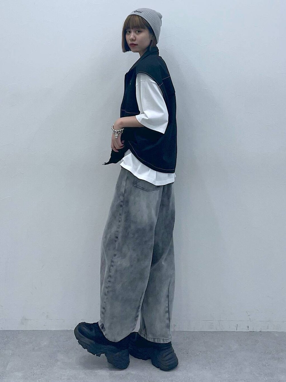 ブラック系のスニーカー、ブラック系のデニムパンツ、ホワイト系のTシャツ/カットソーを着用したレディースの夏コーディネートの4枚目の写真