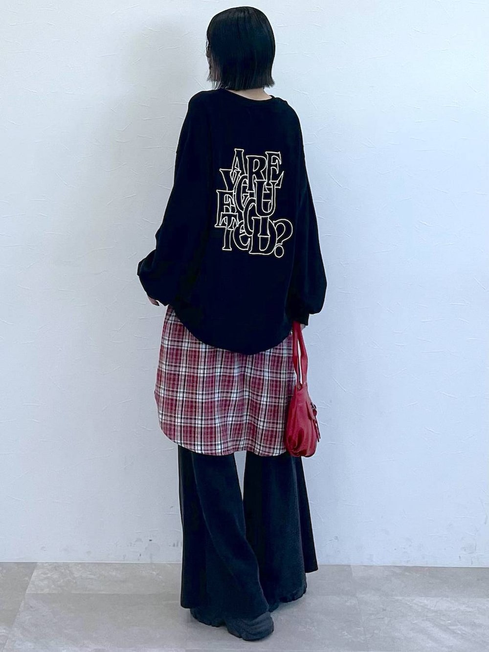 ブラック系のスニーカー、レッド系のシャツ/ブラウス、レッド系のハンドバッグを着用したレディースの秋コーディネートの3枚目の写真