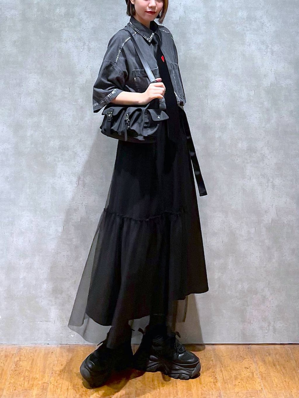 ブラック系のショルダーバッグ、ブラック系のスニーカー、ブラック系のシャツ/ブラウスを着用したレディースの夏コーディネートの4枚目の写真