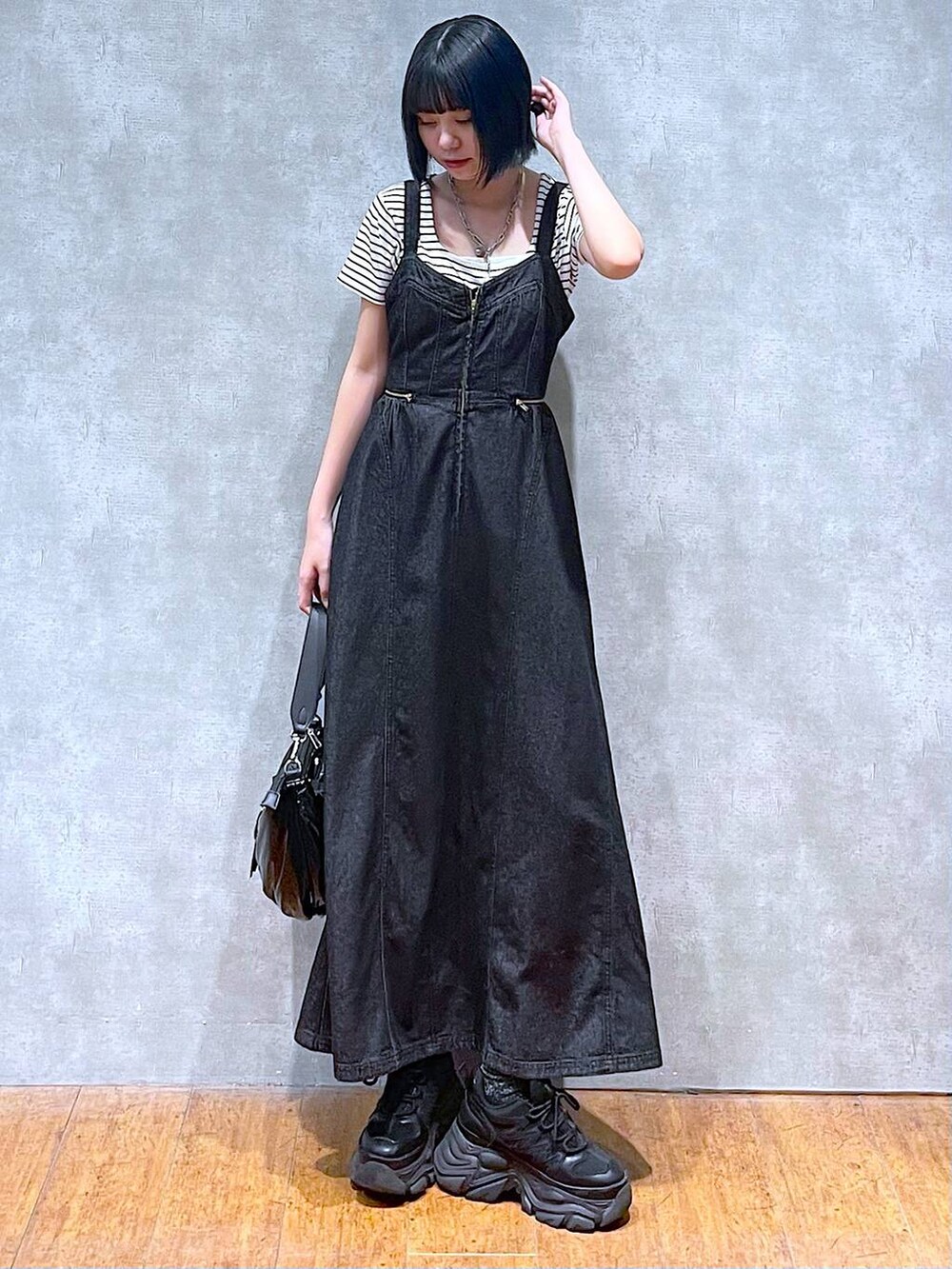 ブラック系のスニーカー、ブラック系のワンピース、ホワイト系のTシャツ/カットソーを着用したレディースの夏コーディネートの2枚目の写真