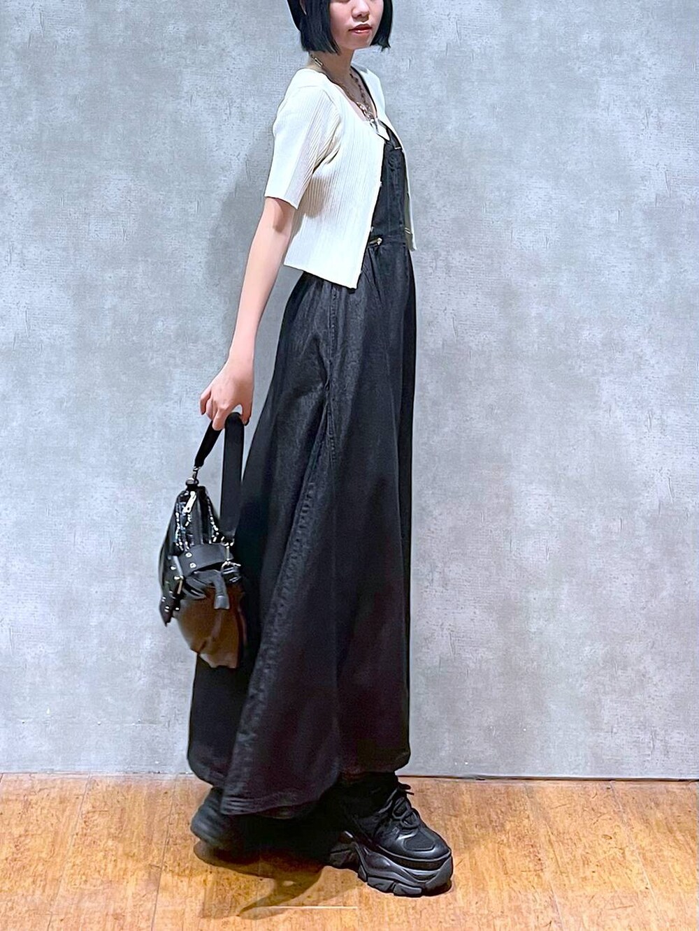 ブラック系のスニーカー、ブラック系のワンピース、ホワイト系のキャミソールを着用したレディースの夏コーディネートの4枚目の写真