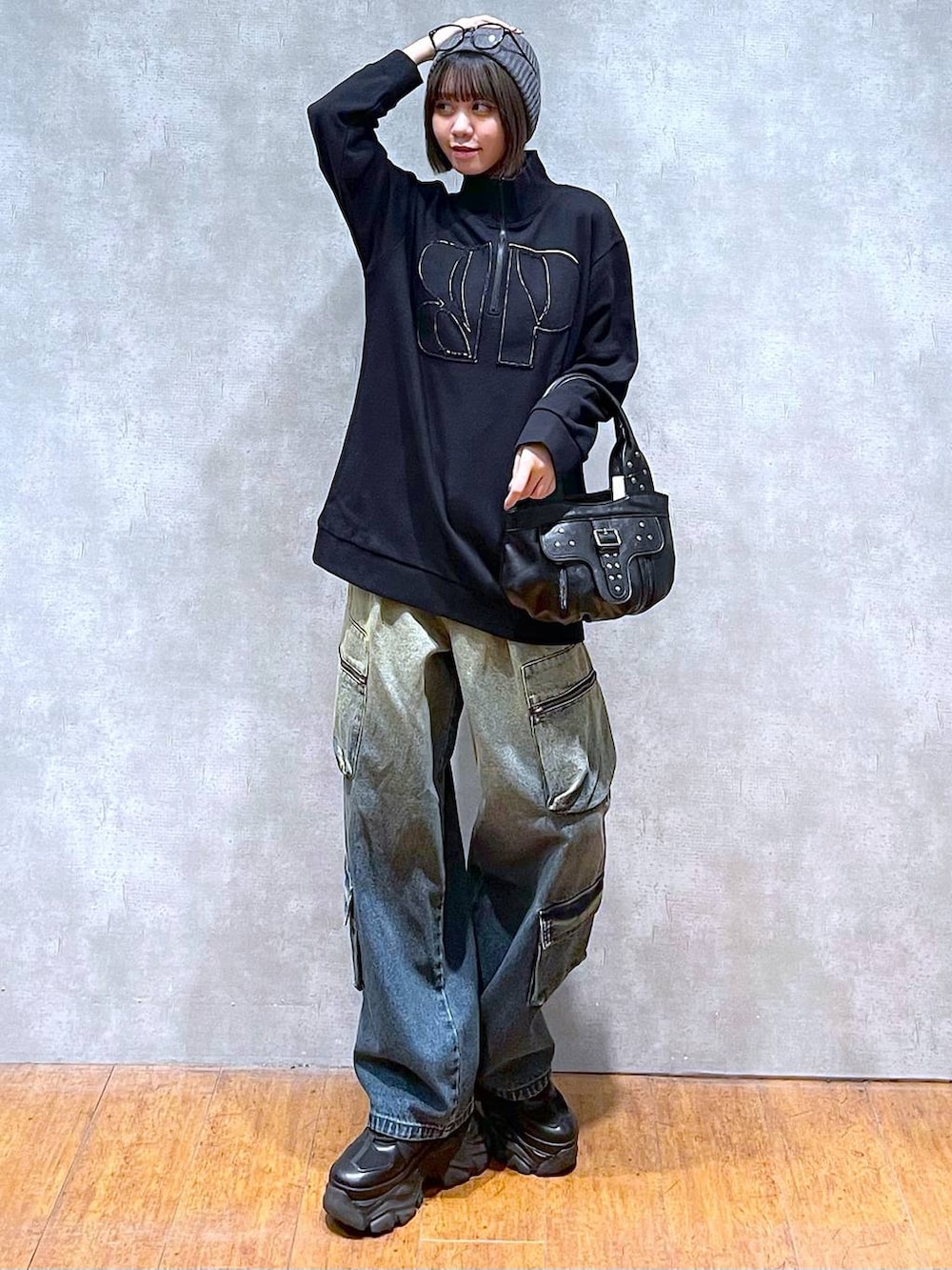 ブラック系のスニーカー、ブルー系のデニムパンツ、ブラック系のハンドバッグを着用したレディースの秋コーディネートの8枚目の写真