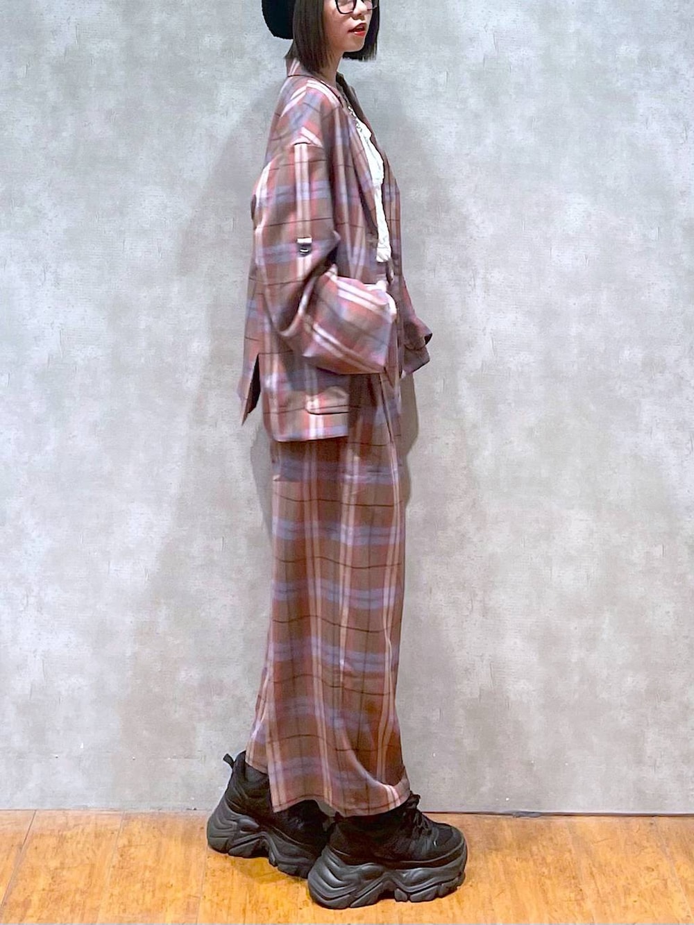 ブラック系のスニーカー、ブラウン系のテーラードジャケット、ブラウン系のスラックスを着用したレディースの秋コーディネートの3枚目の写真