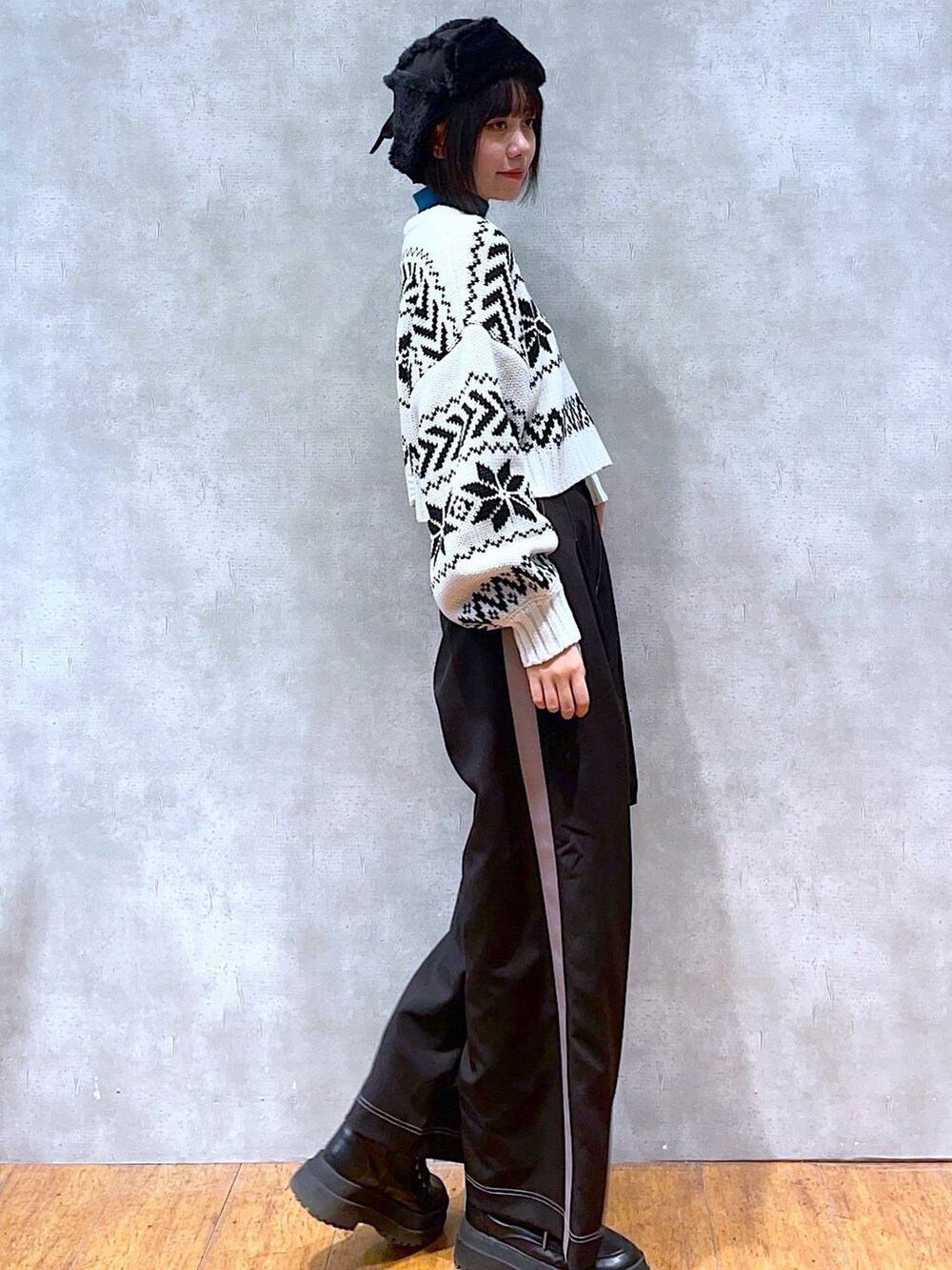 ブラック系のブーツ、ブルー系のニット/セーター、ブラック系のその他パンツを着用したレディースの冬コーディネートの2枚目の写真