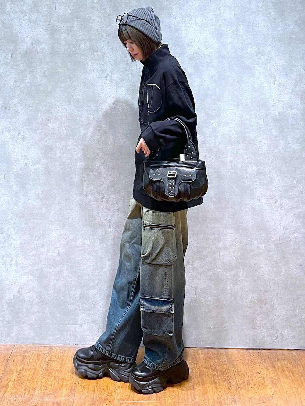 ブラック系のスニーカー、ブルー系のデニムパンツ、ブラック系のハンドバッグを着用したレディースの秋コーディネートの7枚目の写真