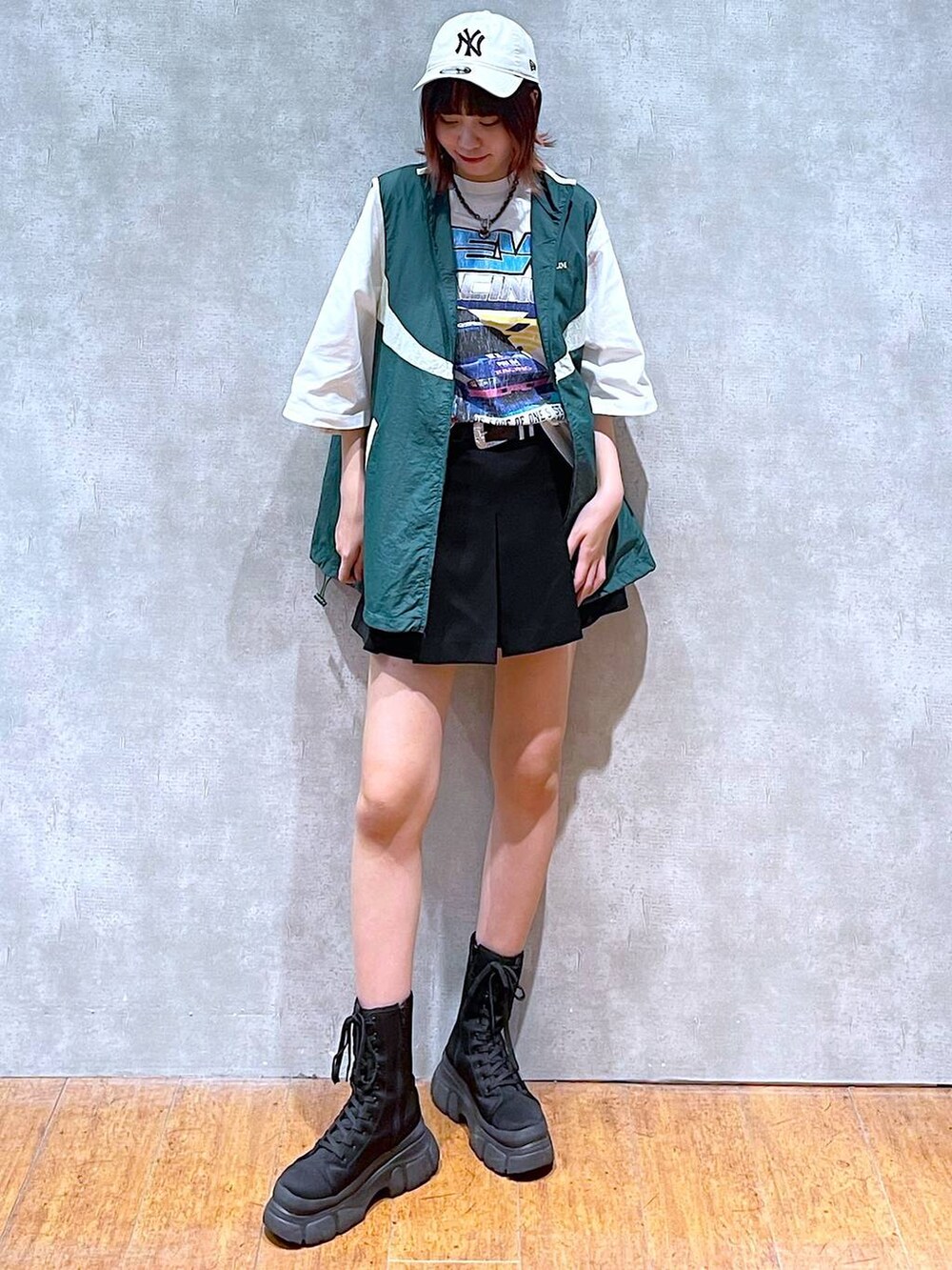 グリーン系のベスト、ホワイト系のTシャツ/カットソー、ブラック系のその他パンツを着用したレディースの春コーディネートの2枚目の写真