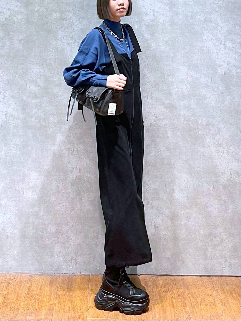 ブラック系のショルダーバッグ、ブラック系のブーツ、ブルー系のニット/セーターを着用したレディースの秋コーディネートの9枚目の写真