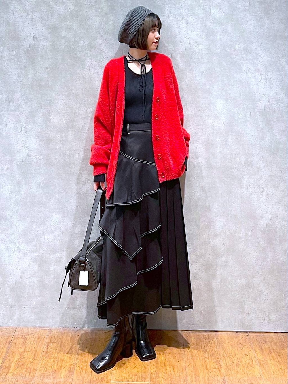 ブラック系のショルダーバッグ、ブラック系のブーツ、ブラック系のスカートを着用したレディースの秋コーディネートの7枚目の写真