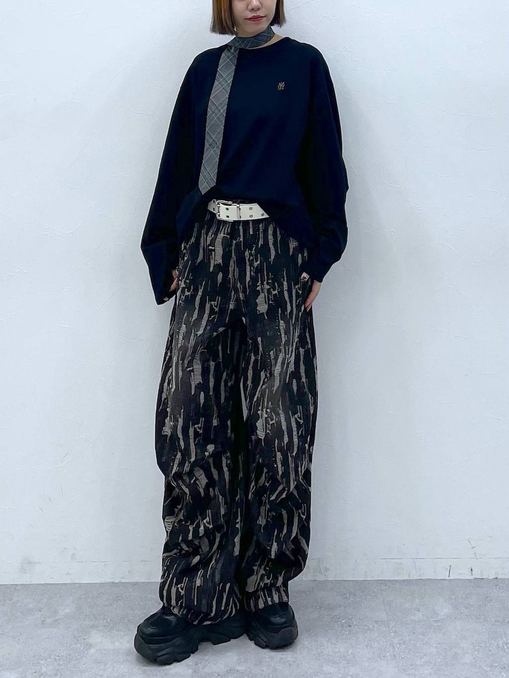 ブラック系のスニーカー、グレー系のネクタイ、ブラック系のデニムパンツを着用したレディースの夏コーディネートの4枚目の写真