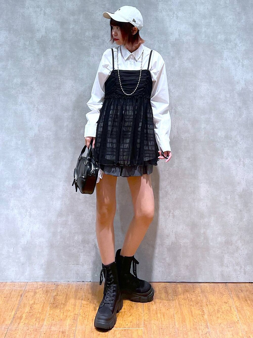 ホワイト系のシャツ/ブラウス、グレー系のその他パンツ、ブラック系のブーツを着用したレディースの春コーディネートの2枚目の写真