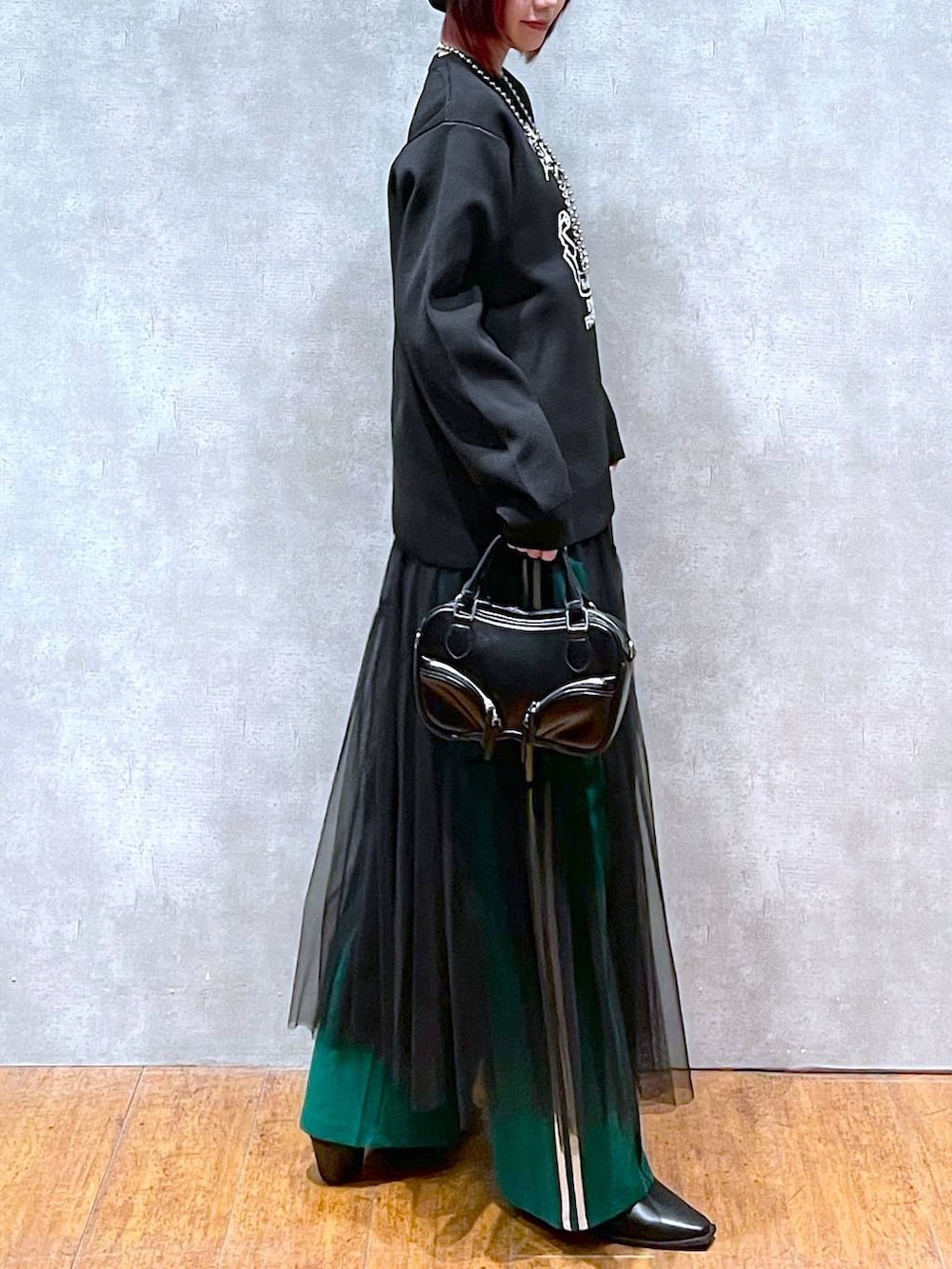 グリーン系のその他パンツ、ブラック系のニット/セーター、ブラック系のボストンバッグを着用したレディースの冬コーディネートの6枚目の写真