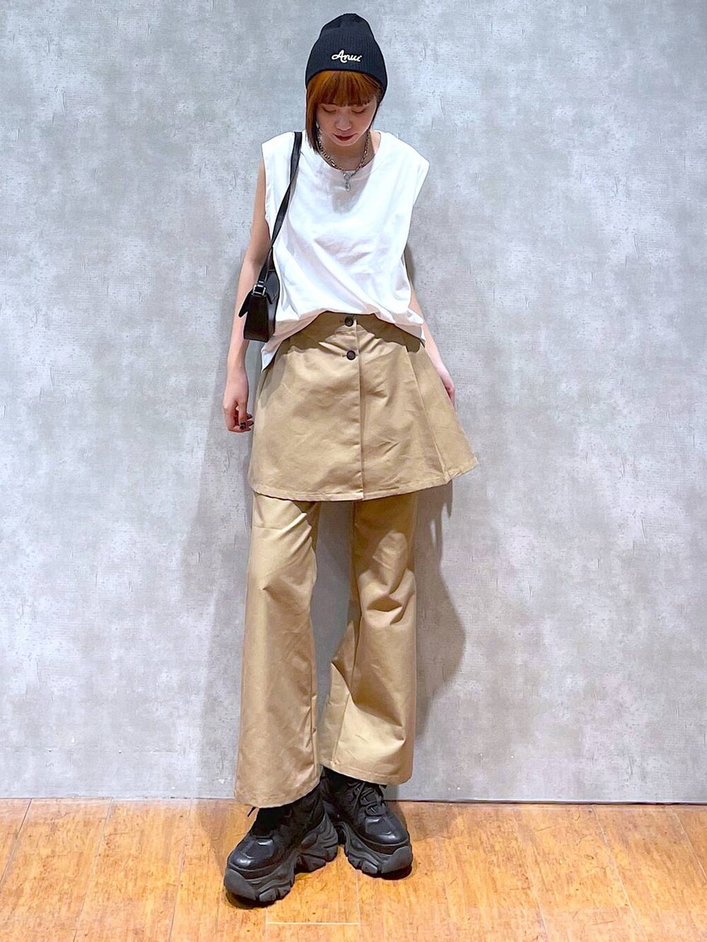 ブラック系のスニーカー、ブラック系のハンドバッグ、ホワイト系のTシャツ/カットソーを着用したレディースの夏コーディネートの3枚目の写真