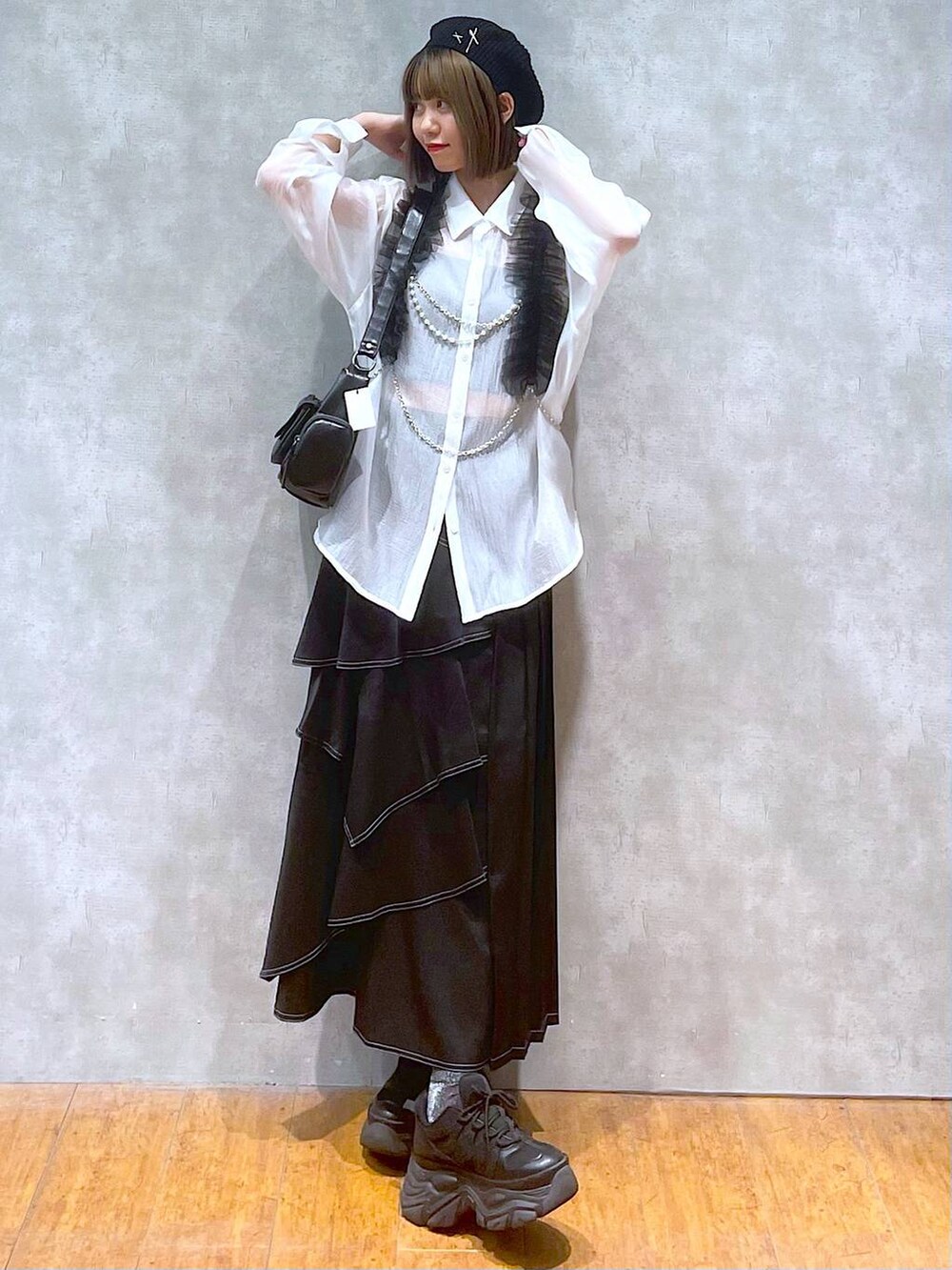 ブラック系のスニーカー、ホワイト系のシャツ/ブラウス、ブラック系のショルダーバッグを着用したレディースの秋コーディネートの2枚目の写真