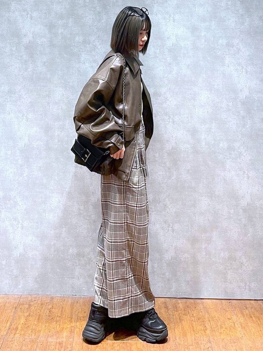 ブラック系のスニーカー、ホワイト系のニット/セーター、ベージュ系のスラックスを着用したレディースの秋コーディネートの5枚目の写真