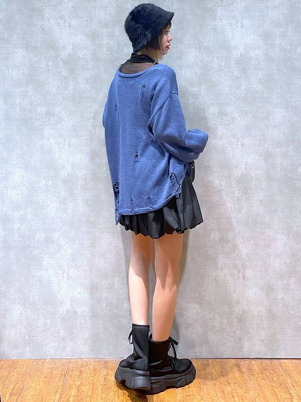 ブラック系のTシャツ/カットソー、ブラック系のスカート、ブラック系のボストンバッグを着用したレディースの冬コーディネートの5枚目の写真