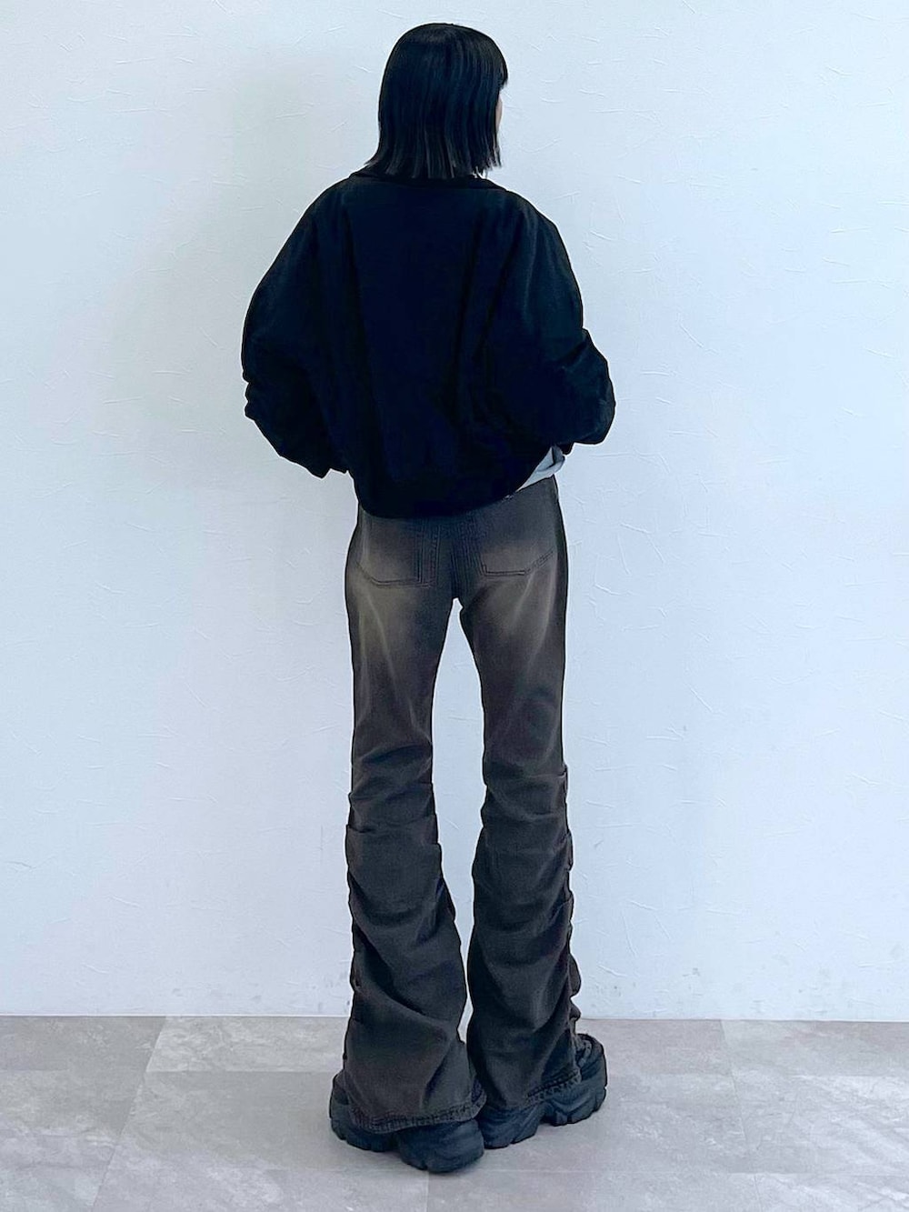 ブラック系のスニーカー、ブラック系のデニムパンツ、グレー系のTシャツ/カットソーを着用したレディースの秋コーディネートの3枚目の写真