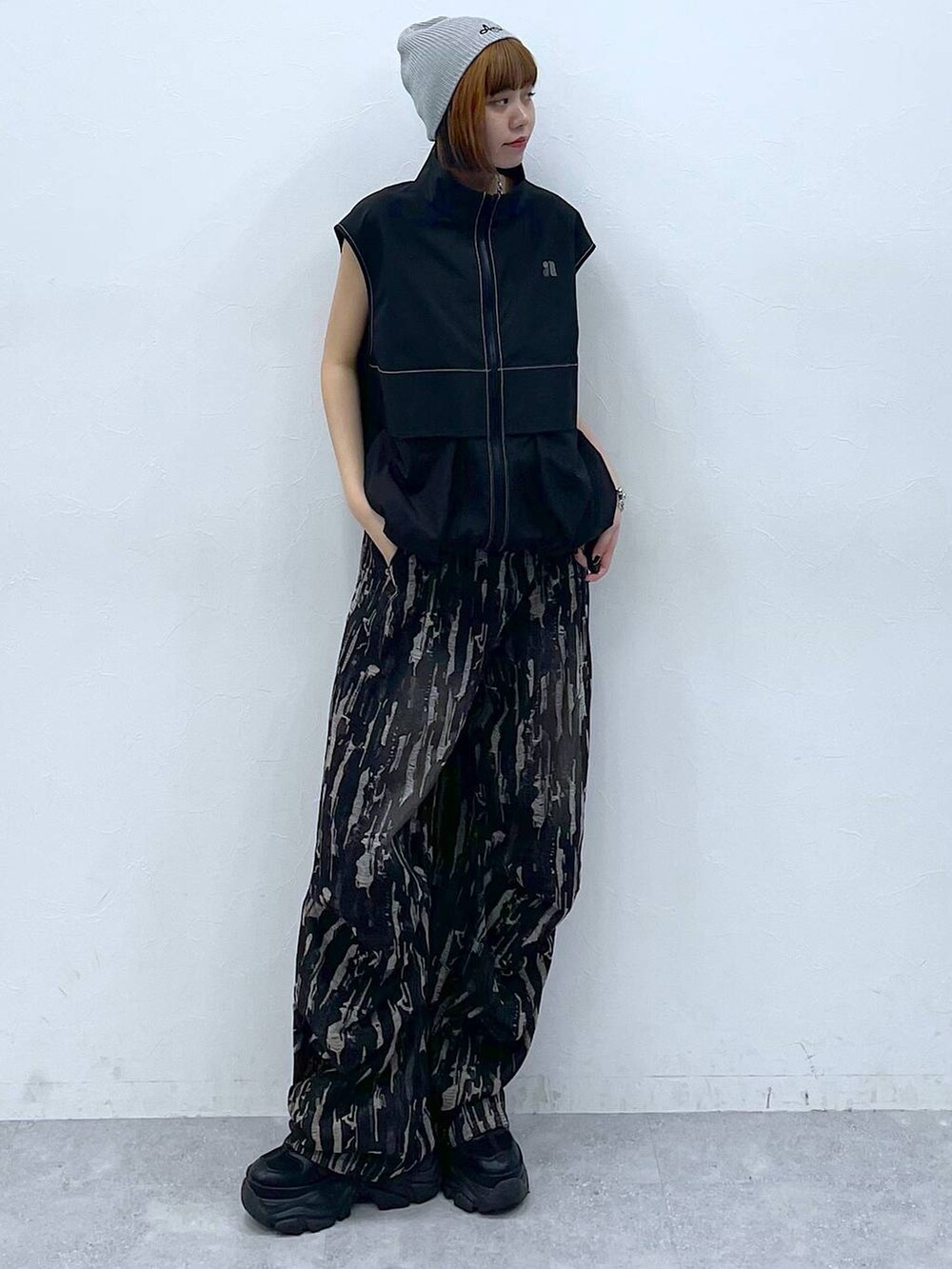 ブラック系のスニーカー、ブラック系のベスト、ブラック系のデニムパンツを着用したレディースの夏コーディネートの8枚目の写真