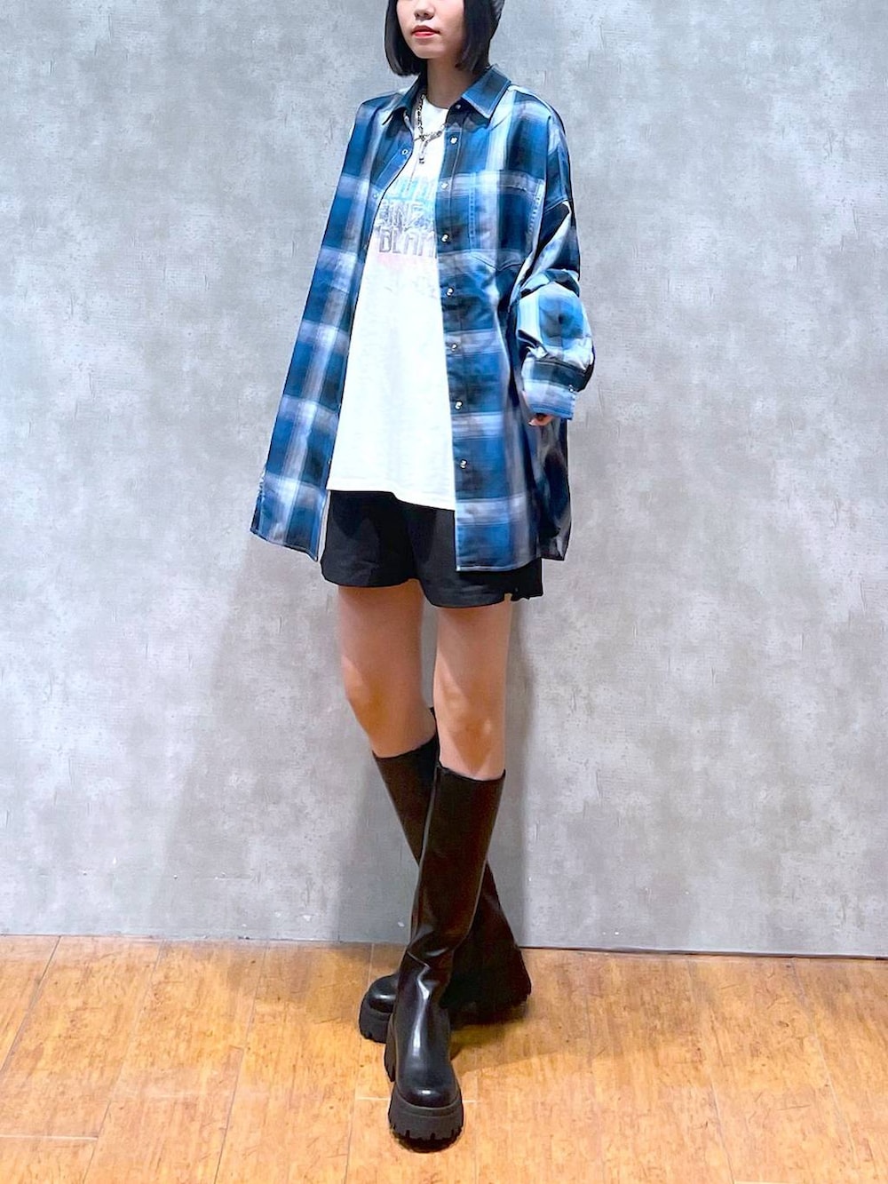 ホワイト系のTシャツ/カットソー、ブルー系のシャツ/ブラウス、ブラック系のブーツを着用したレディースの秋コーディネートの3枚目の写真