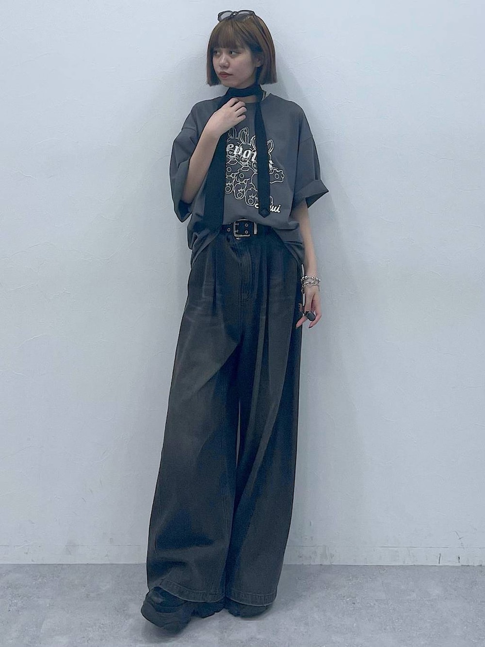 ブラック系のスニーカー、ブラック系のデニムパンツ、グレー系のTシャツ/カットソーを着用したレディースの夏コーディネートの3枚目の写真