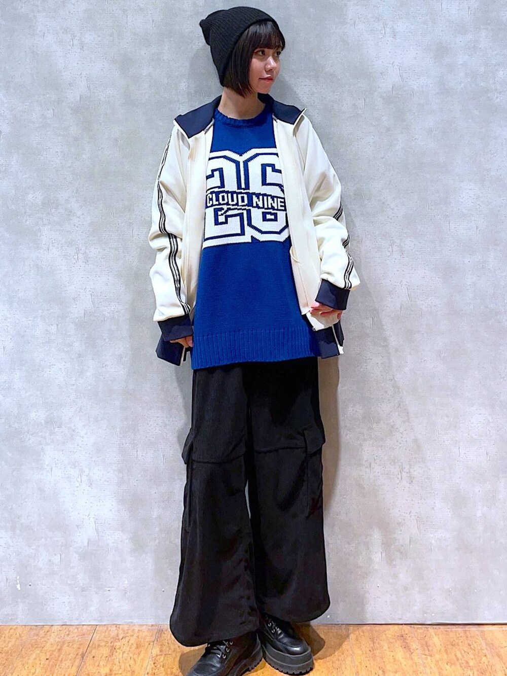 ブラック系のブーツ、ホワイト系のセットアップ、ブラック系のカーゴパンツを着用したレディースの冬コーディネートの3枚目の写真