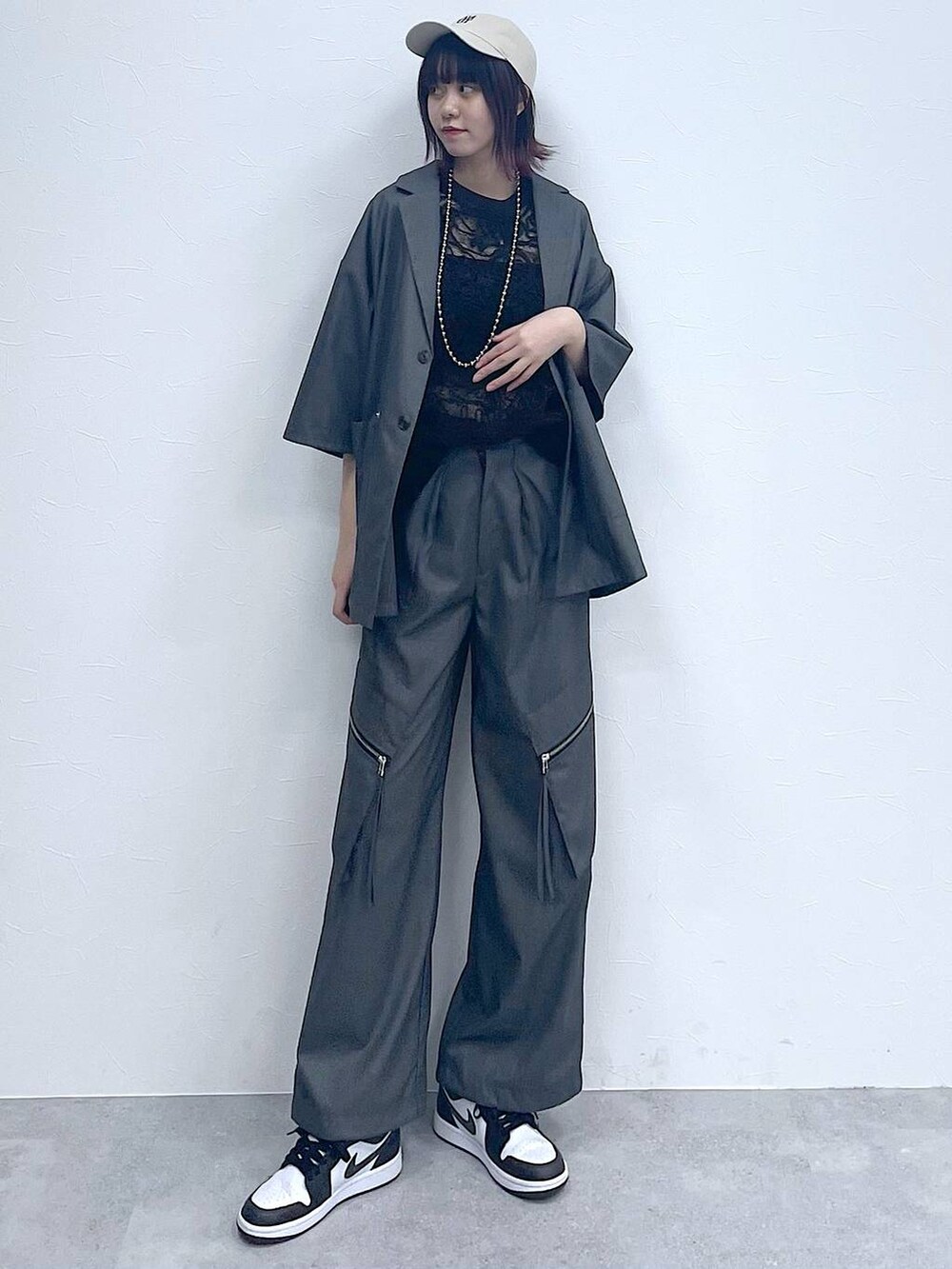 グレー系のスラックス、グレー系のテーラードジャケット、ブラック系のTシャツ/カットソーを着用したレディースの春コーディネートの2枚目の写真