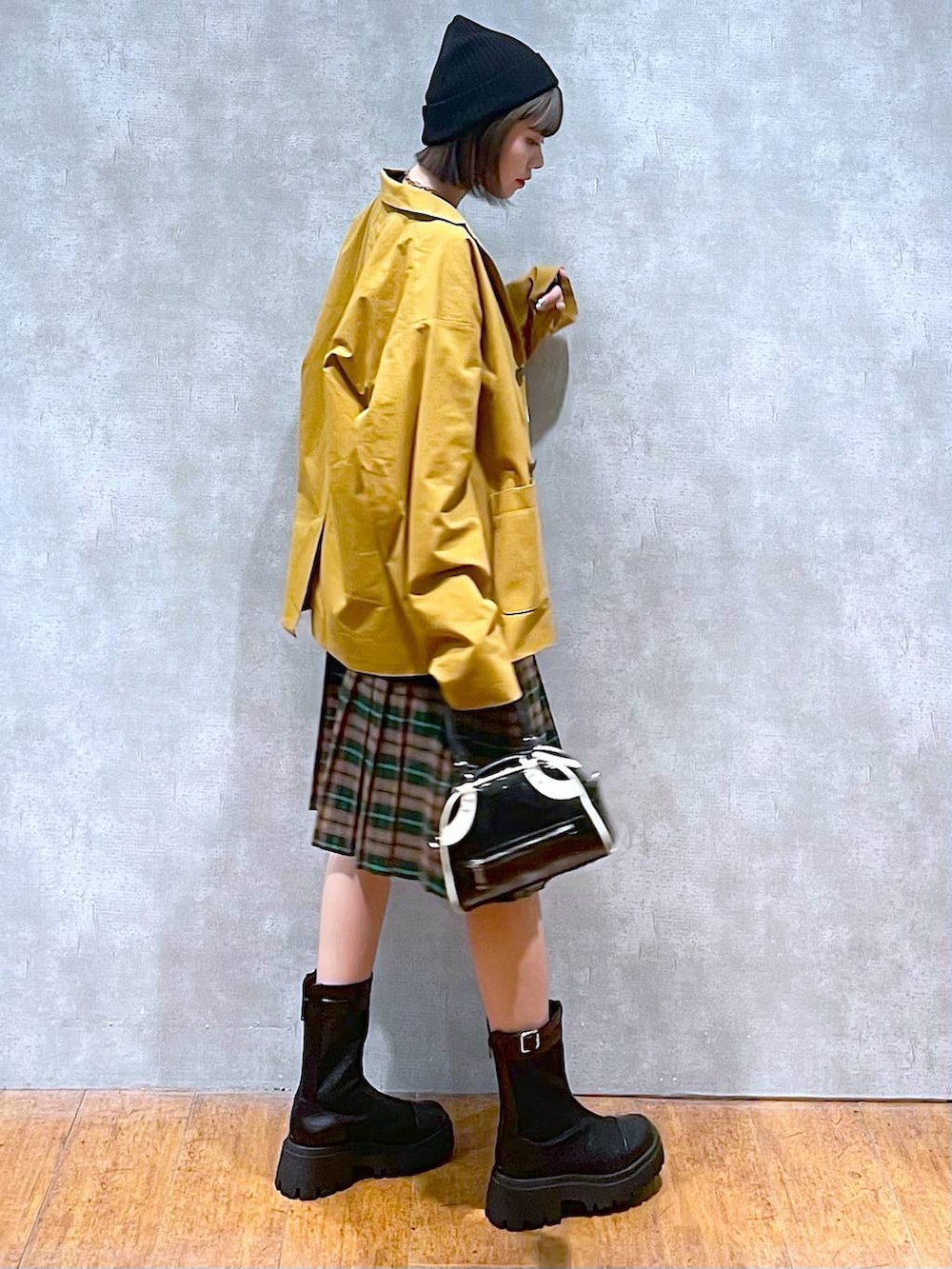 ブラック系のブーツ、ブラック系のショルダーバッグ、ブラック系のTシャツ/カットソーを着用したレディースの秋コーディネートの8枚目の写真