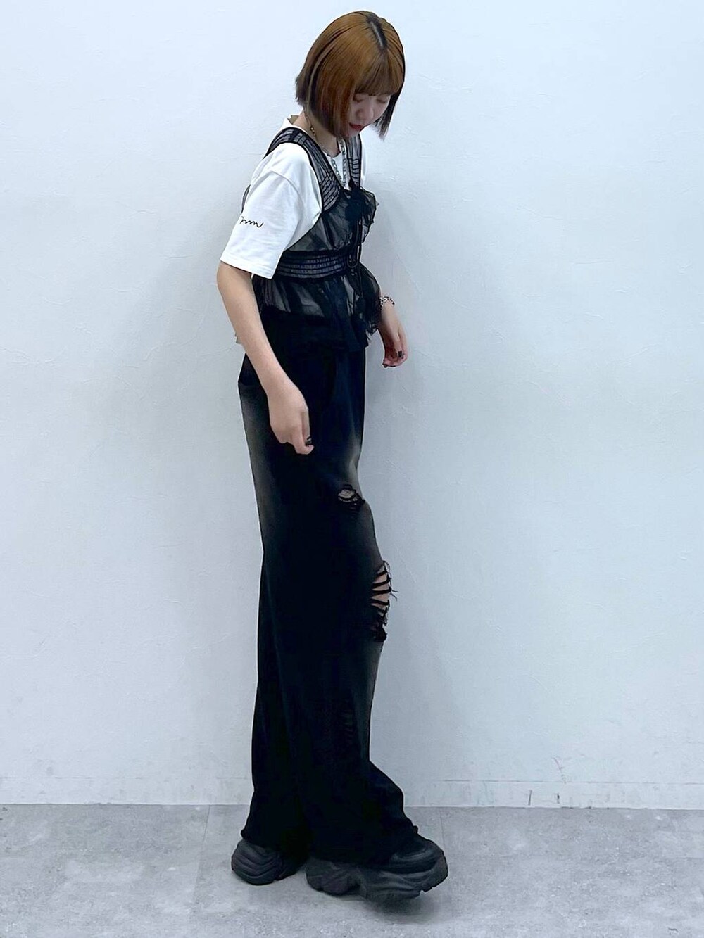 ブラック系のスニーカー、ブラック系のベスト、ホワイト系のTシャツ/カットソーを着用したレディースの夏コーディネートの4枚目の写真