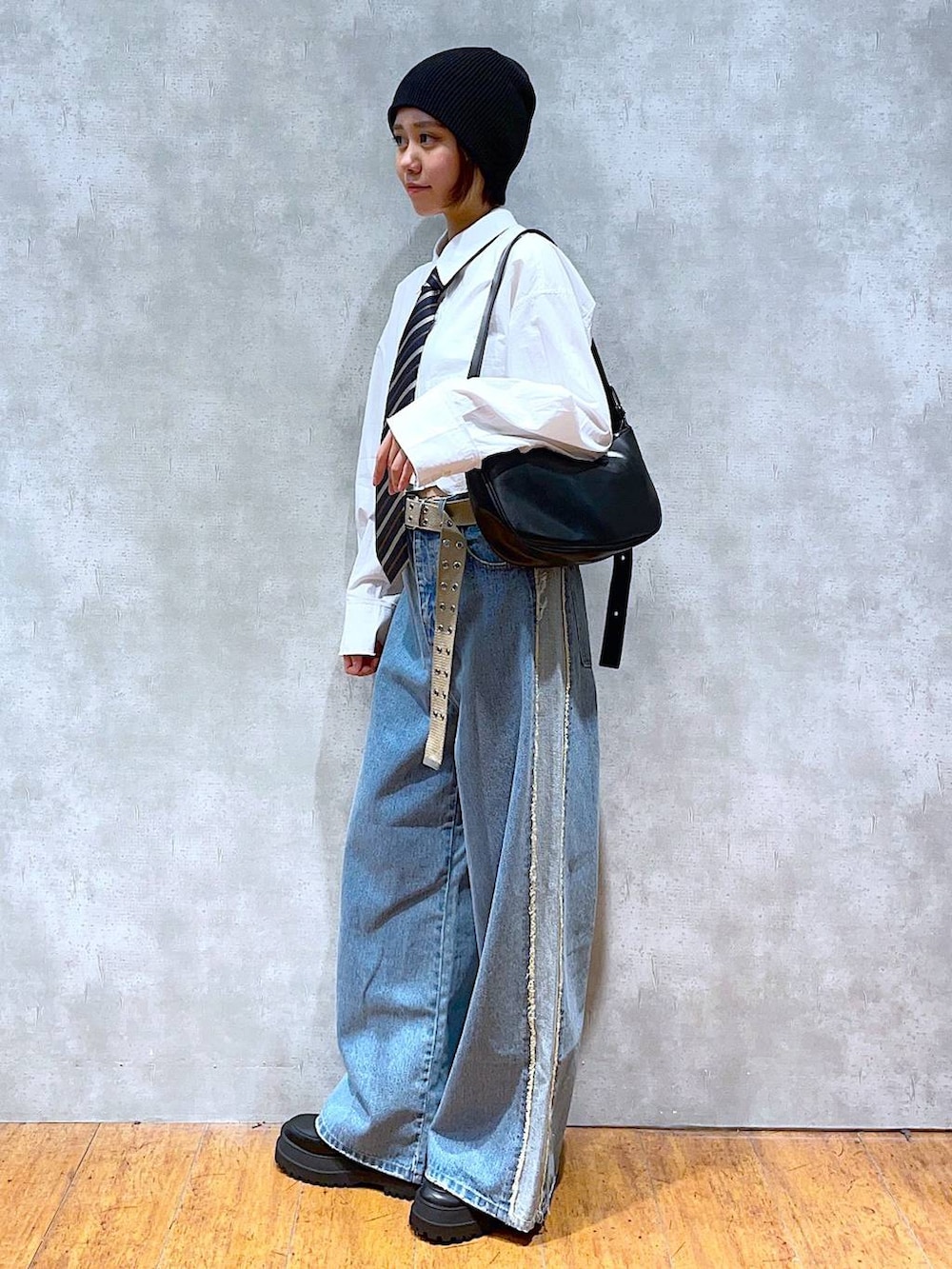 ブラック系のブーツ、ブラック系のショルダーバッグ、ホワイト系のシャツ/ブラウスを着用したレディースの秋コーディネートの2枚目の写真