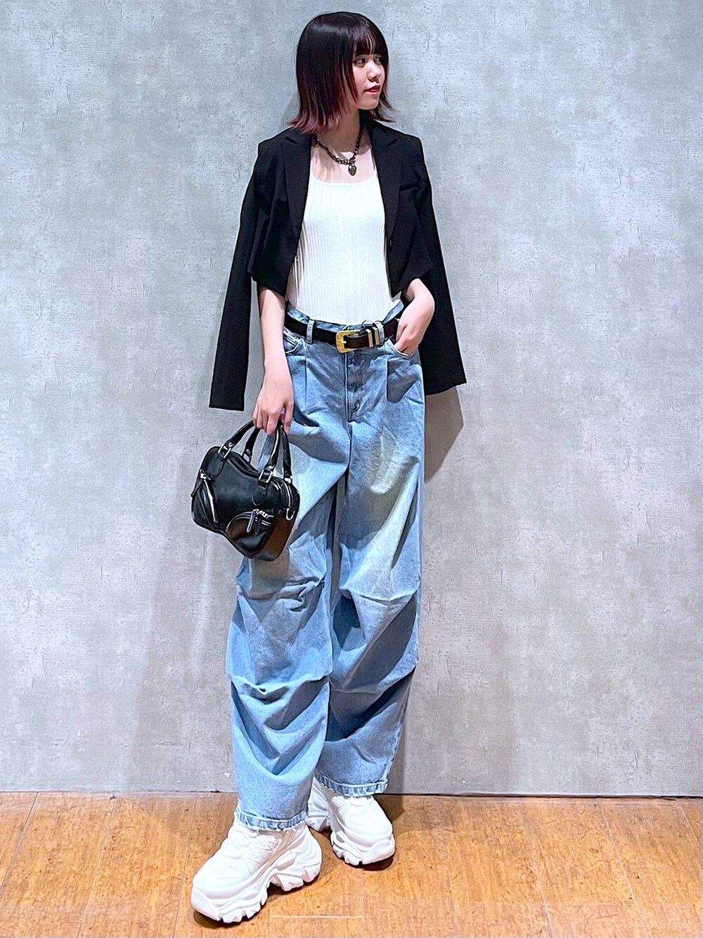 ホワイト系のタンクトップ、ホワイト系のスニーカー、ブラック系のボストンバッグを着用したレディースの春コーディネートの3枚目の写真