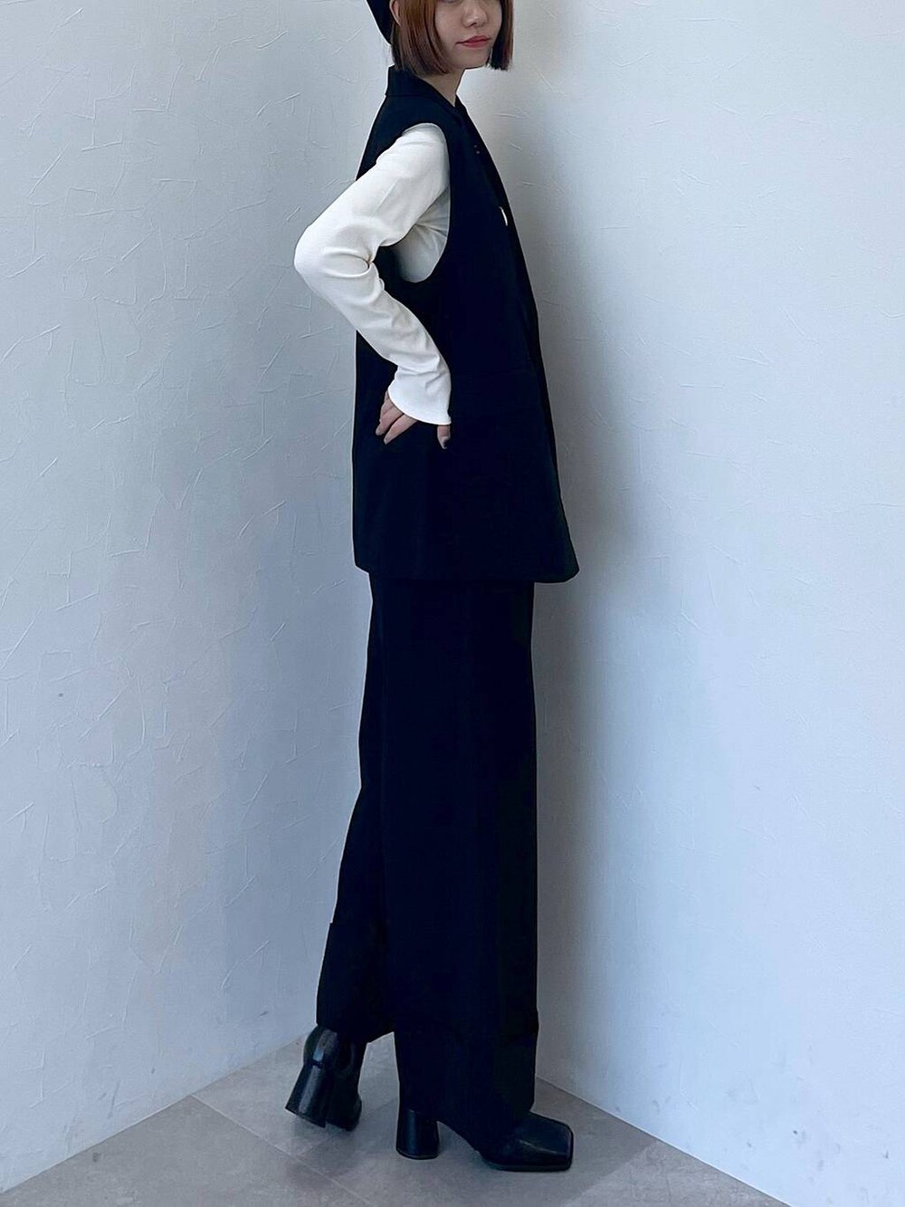 ブラック系のその他パンツ、ブラック系のベスト、ホワイト系のTシャツ/カットソーを着用したレディースの秋コーディネートの2枚目の写真