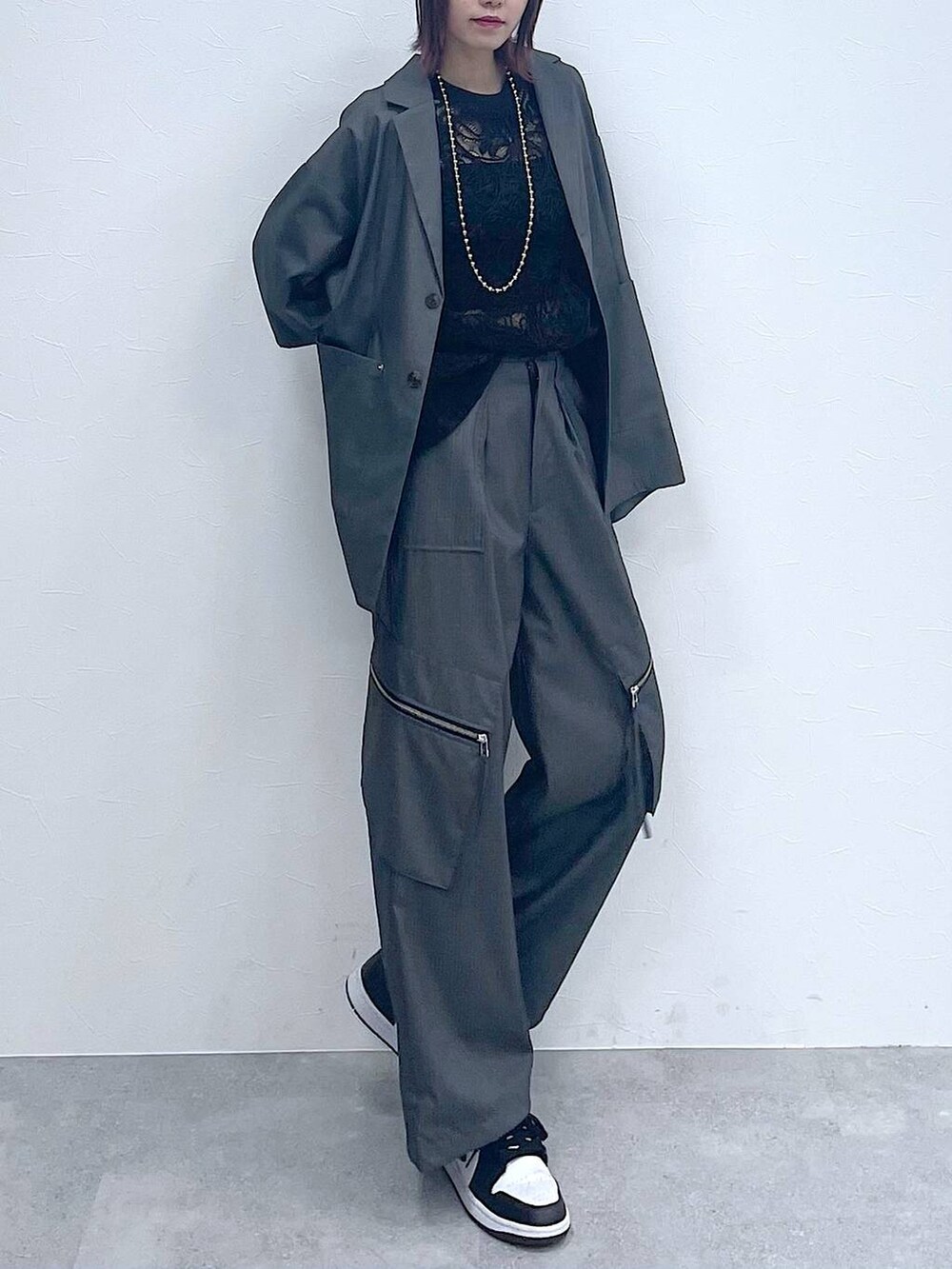 グレー系のスラックス、グレー系のテーラードジャケット、ブラック系のTシャツ/カットソーを着用したレディースの春コーディネートの4枚目の写真