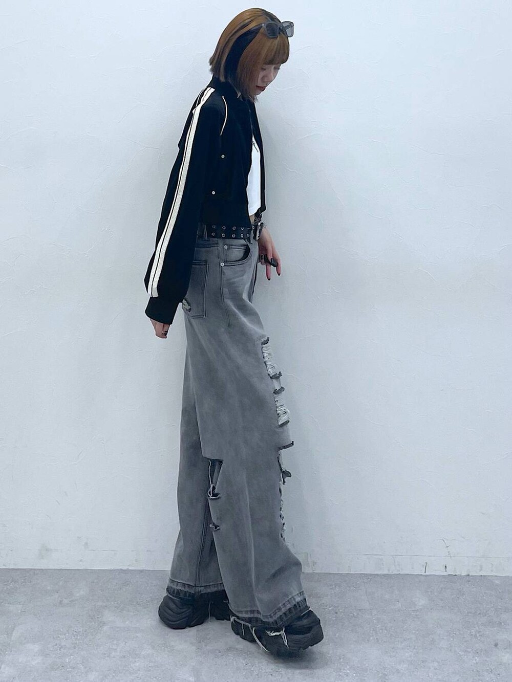 ブラック系のデニムパンツ、ブラック系のスニーカー、ホワイト系のTシャツ/カットソーを着用したレディースの夏コーディネートの5枚目の写真