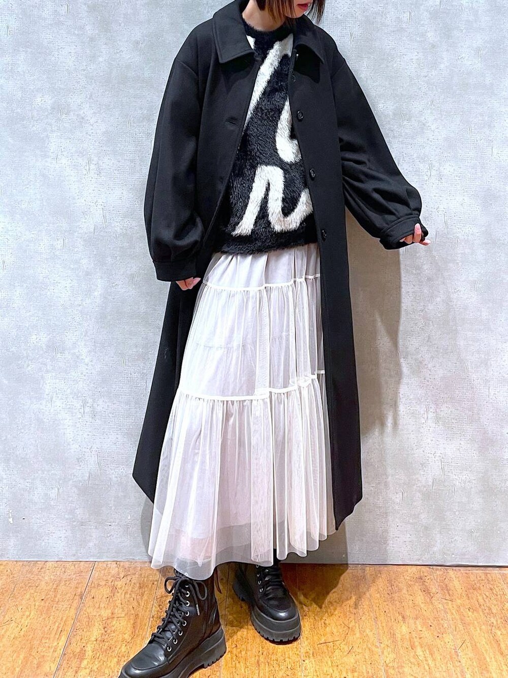 ブラック系のブーツ、ブラック系のチェスターコート、ブラック系のニット/セーターを着用したレディースの冬コーディネートの5枚目の写真